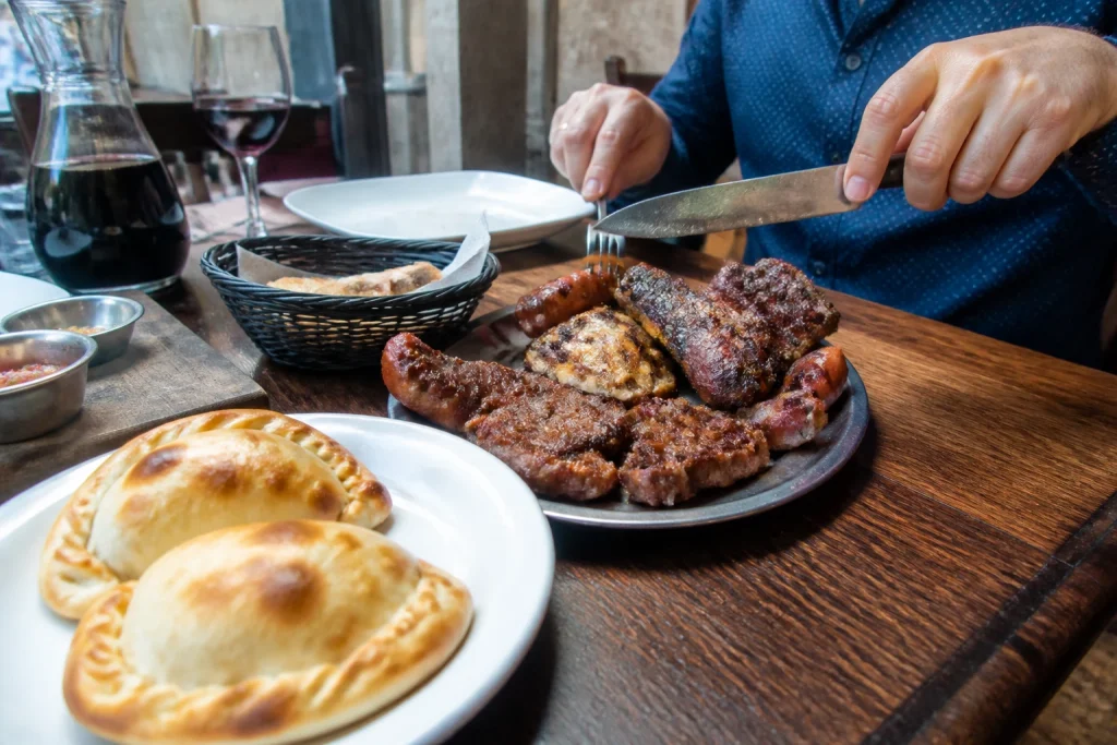 Argentine empanadas and grilled food served at a restaurant table in Mendoza City