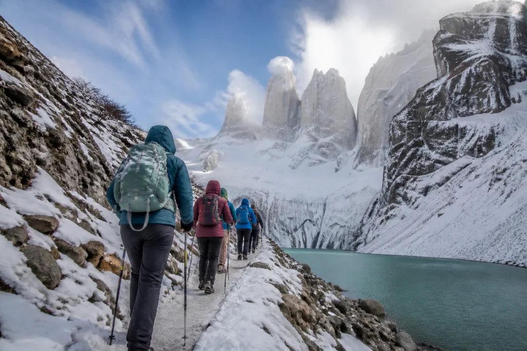 Guided hikers on the Base Torres trail in winter conditions.